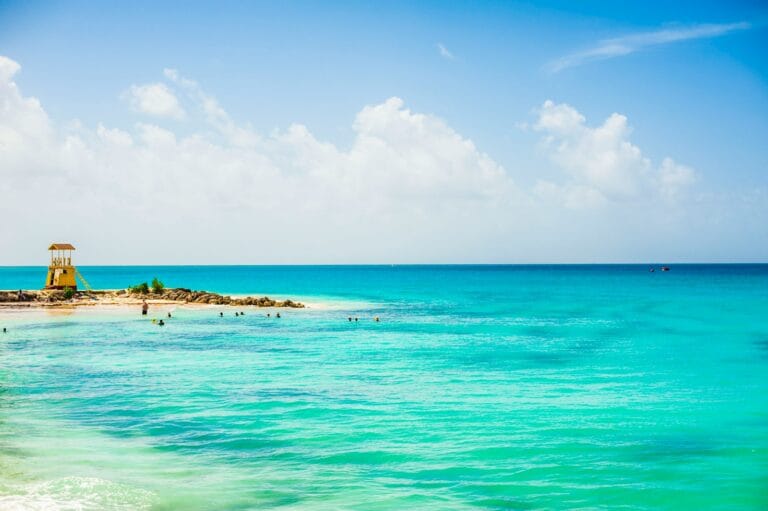 Barbados Travel Guide a view of a beach with people swimming in the water