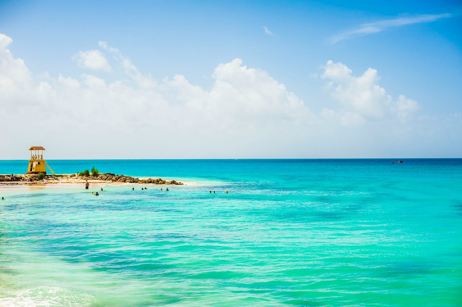 Barbados Travel Guide a view of a beach with people swimming in the water