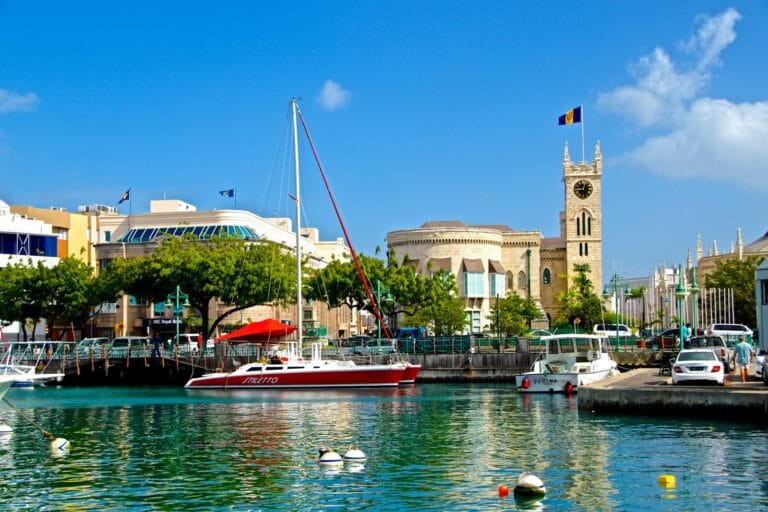Barbados Tours white and red boat on water near brown concrete building during daytime