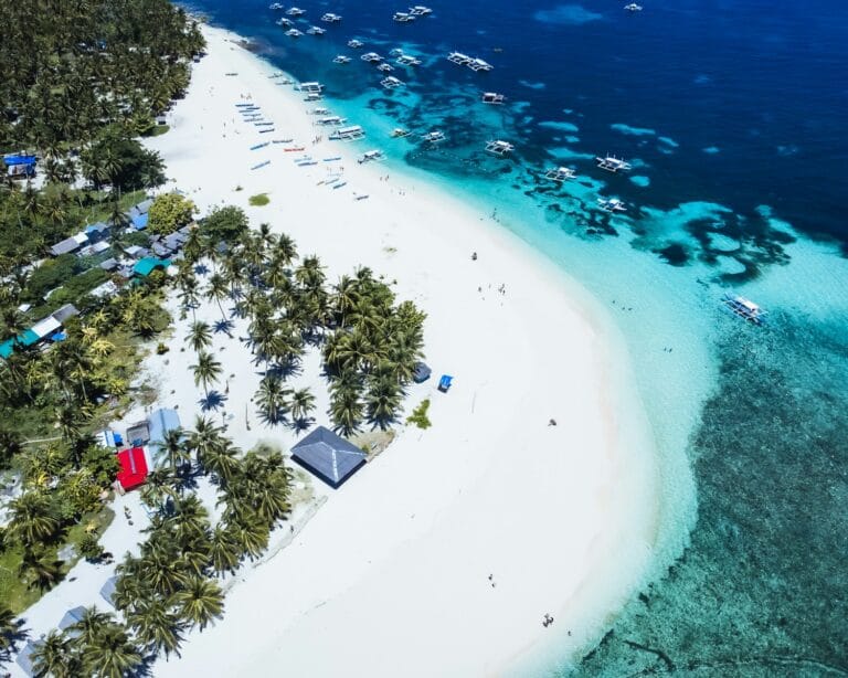 Siargao Island Travel Guide An aerial view of a tropical island with a white sand beach