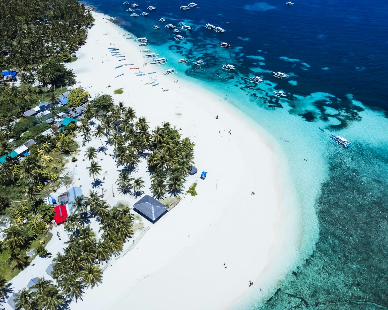 Siargao Island Travel Guide An aerial view of a tropical island with a white sand beach