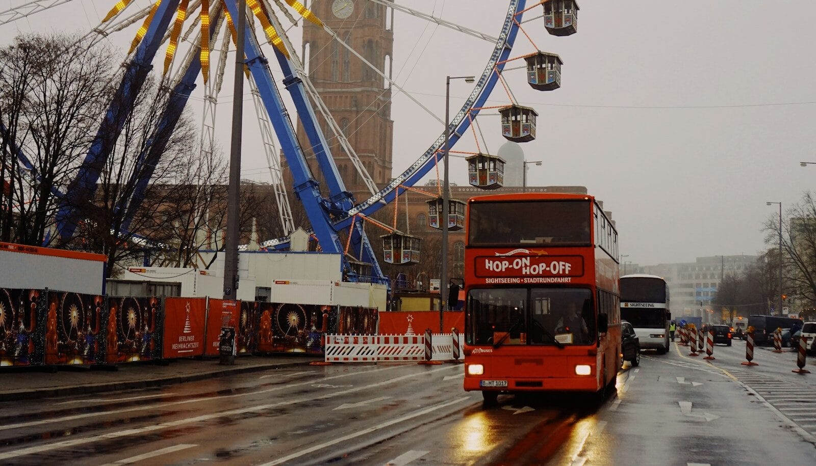 big bus tours, red bus on asphalt road near white and blue ferris wheel