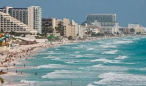 Cancun Travel Guide A beach with a bunch of people on it