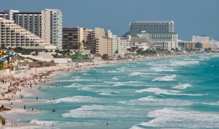 Cancun Travel Guide A beach with a bunch of people on it