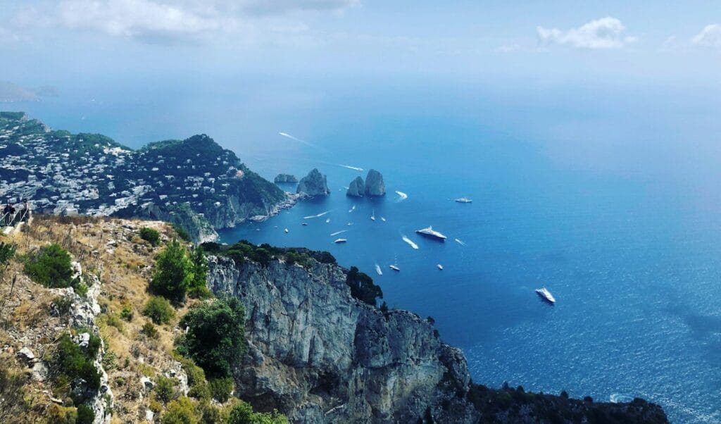 Capri Tours, green and brown mountain beside body of water under white clouds and blue sky during daytime