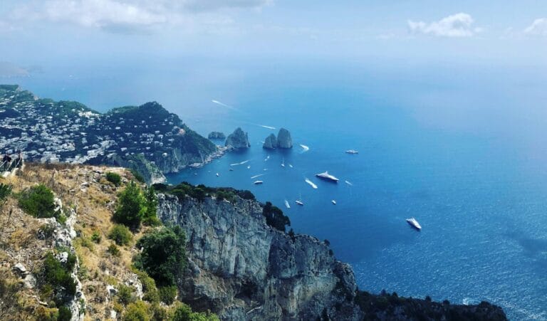 Capri Tours, green and brown mountain beside body of water under white clouds and blue sky during daytime