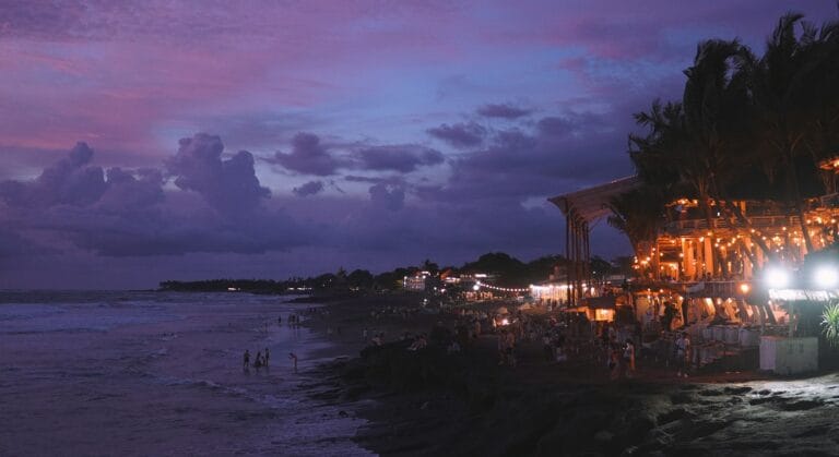 Canggu Tours a body of water with buildings along it and a bridge with lights