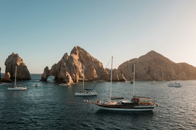El Arco de Cabo San Lucas a group of boats floating on top of a body of water