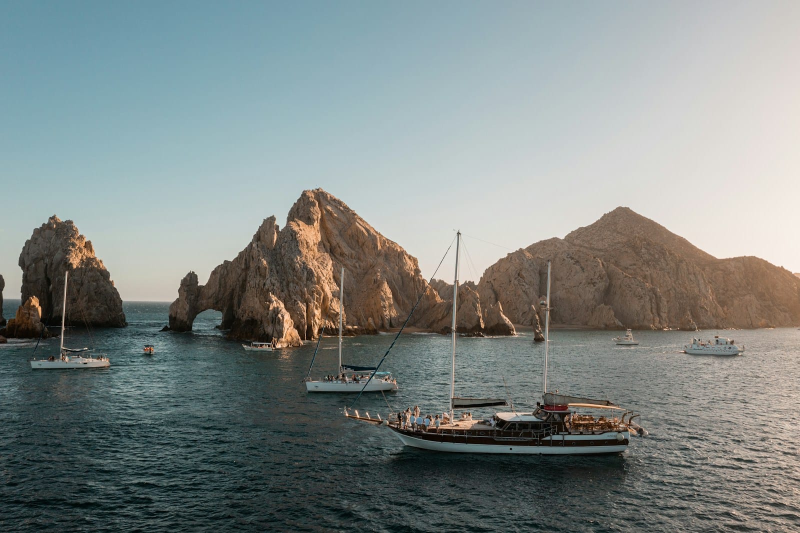 El Arco de Cabo San Lucas a group of boats floating on top of a body of water