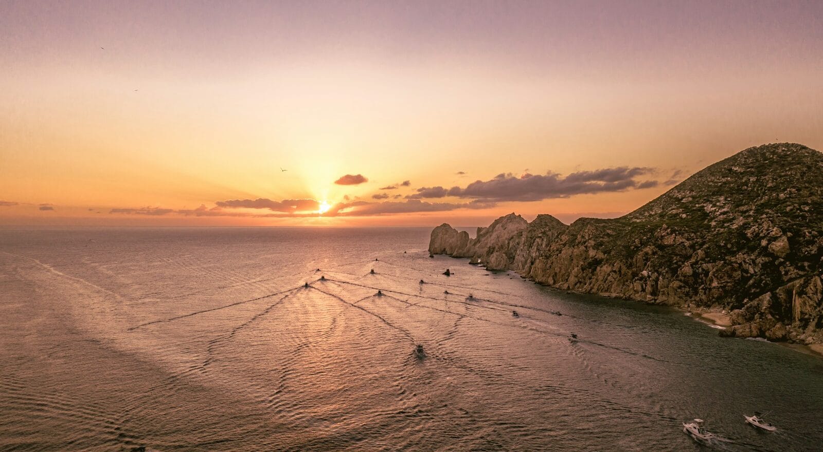 Arch of Cabo San Lucas – Iconic Ocean Landmark in Baja white rock formation on blue sea during daytime, a snowy beach with a sunset