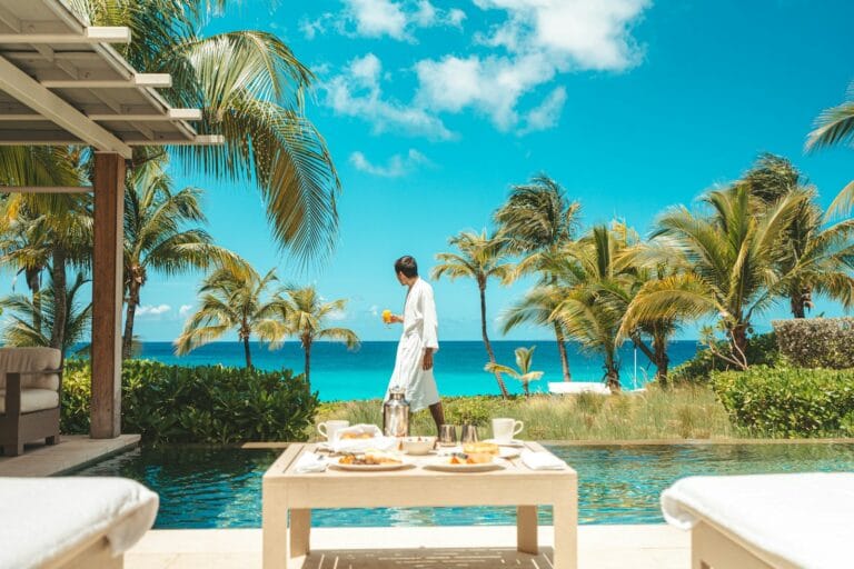 Anguilla Travel Guide a person standing next to a table with food and drinks on it