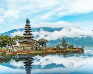 bali travel guide brown and green temple near body of water under blue and white cloudy sky during daytime