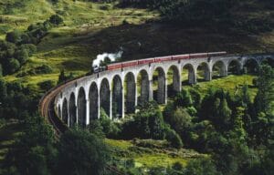United Kingdom Travel Guide train on bridge surrounded with trees at daytime
