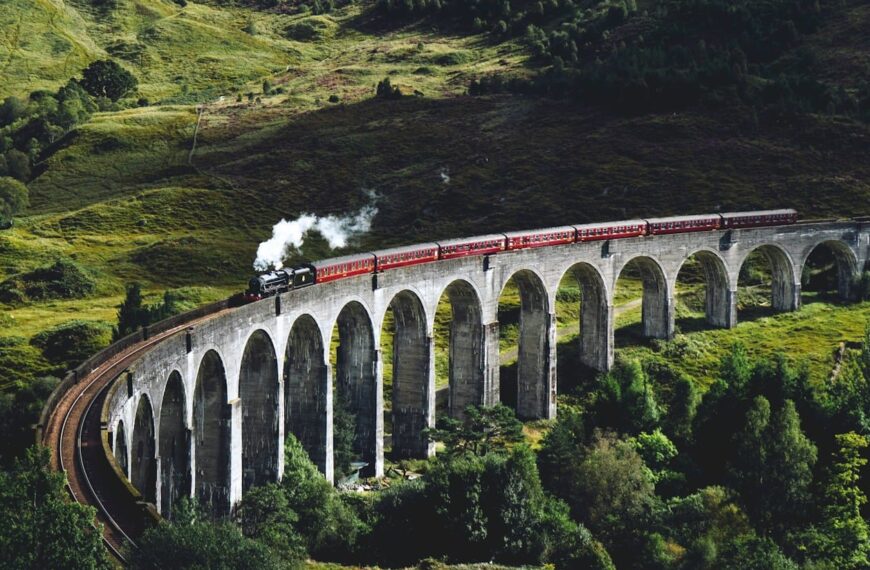 United Kingdom Travel Guide train on bridge surrounded with trees at daytime