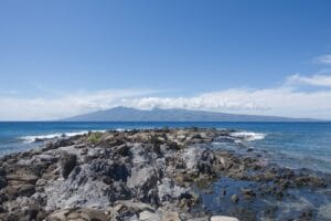 Molokai Travel Guide a rocky beach with a body of water in the background