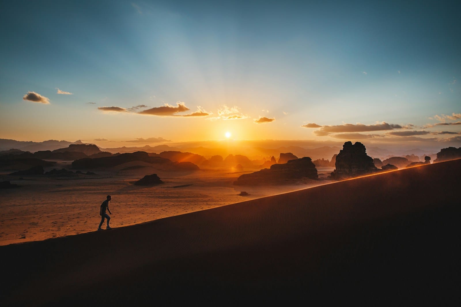 a woman sitting on top of a sand dune