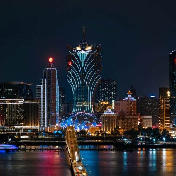 Macau Travel Guide a city skyline at night with a bridge going across it
