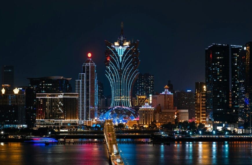 Macau Travel Guide a city skyline at night with a bridge going across it