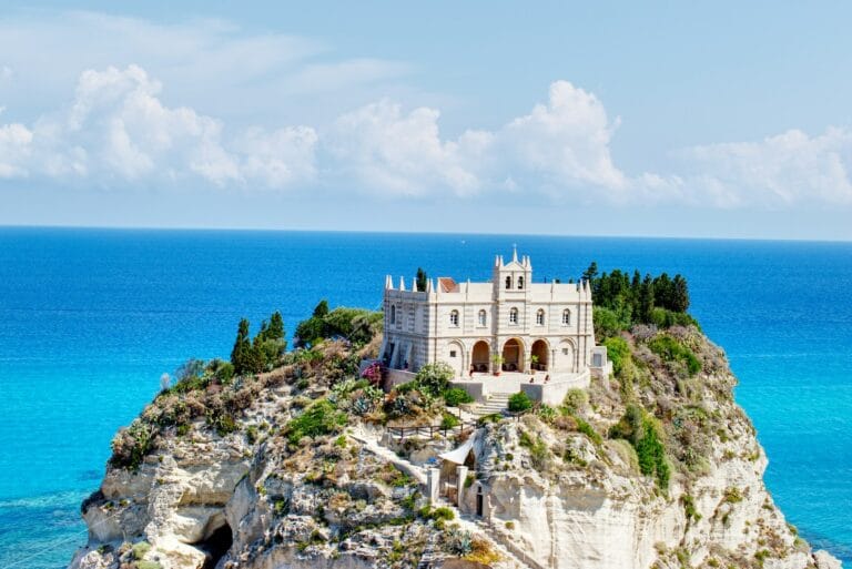 tropea tours white and brown concrete building near body of water during daytime