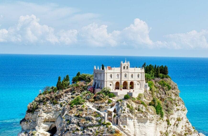 tropea tours white and brown concrete building near body of water during daytime