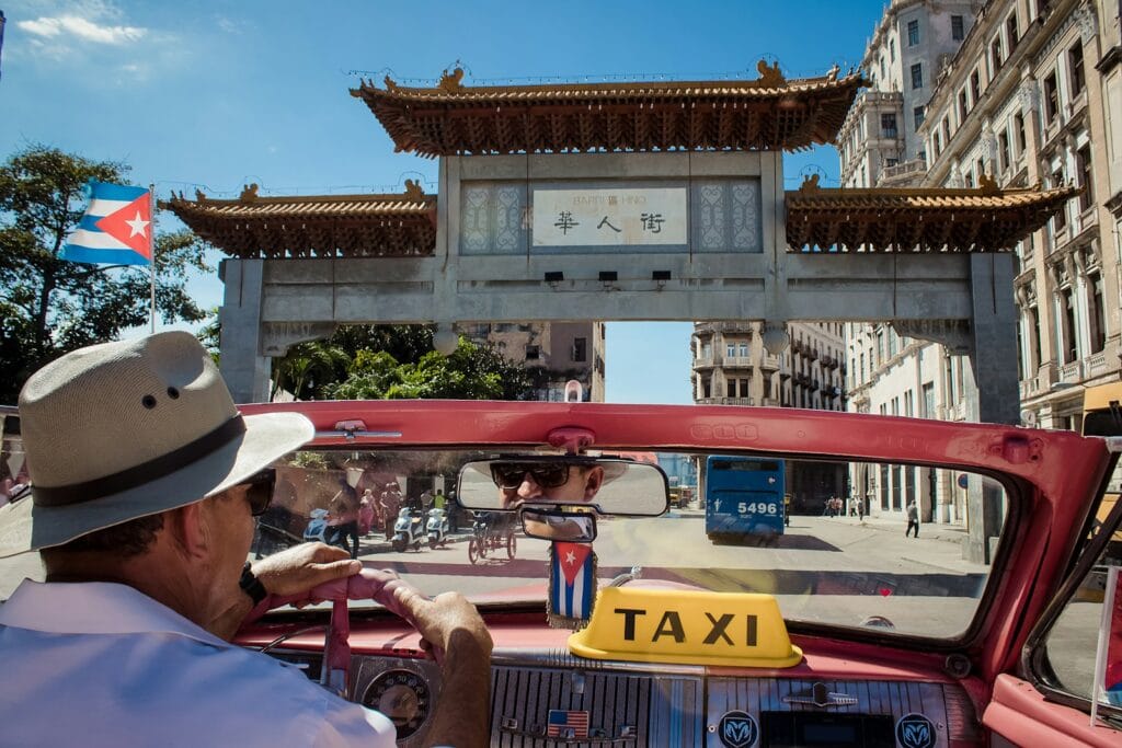 Cuba Travel Guide Best Time to Visit Cuba man driving red Taxi during daytime