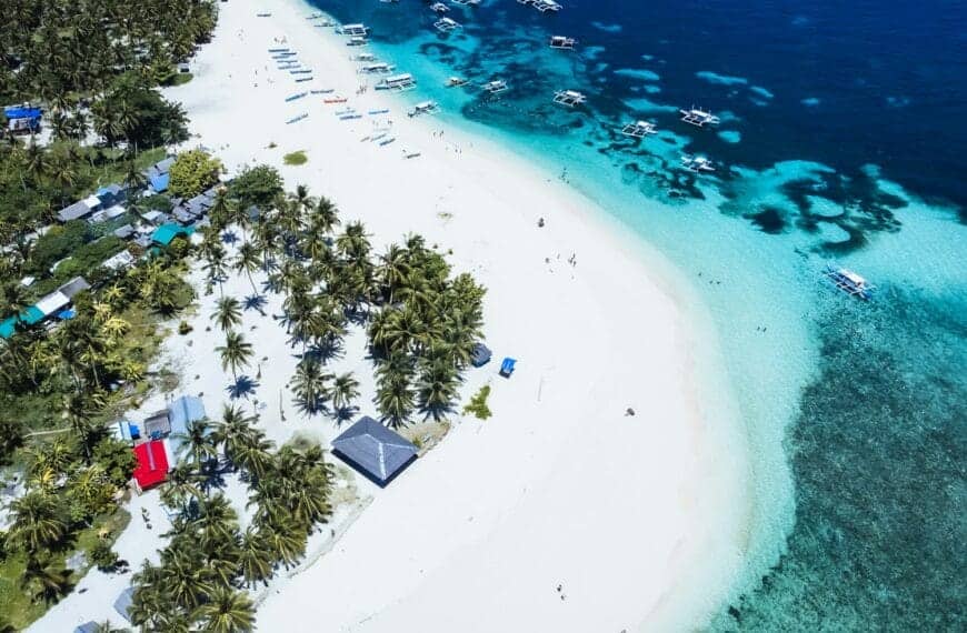 Siargao Island tours An aerial view of a tropical island with a white sand beach