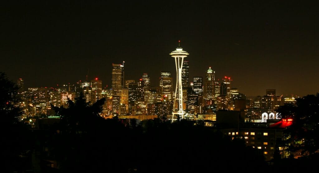 Seattle Travel Guide a view of a city at night with the space needle in the background