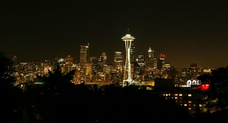 Seattle Travel Guide a view of a city at night with the space needle in the background