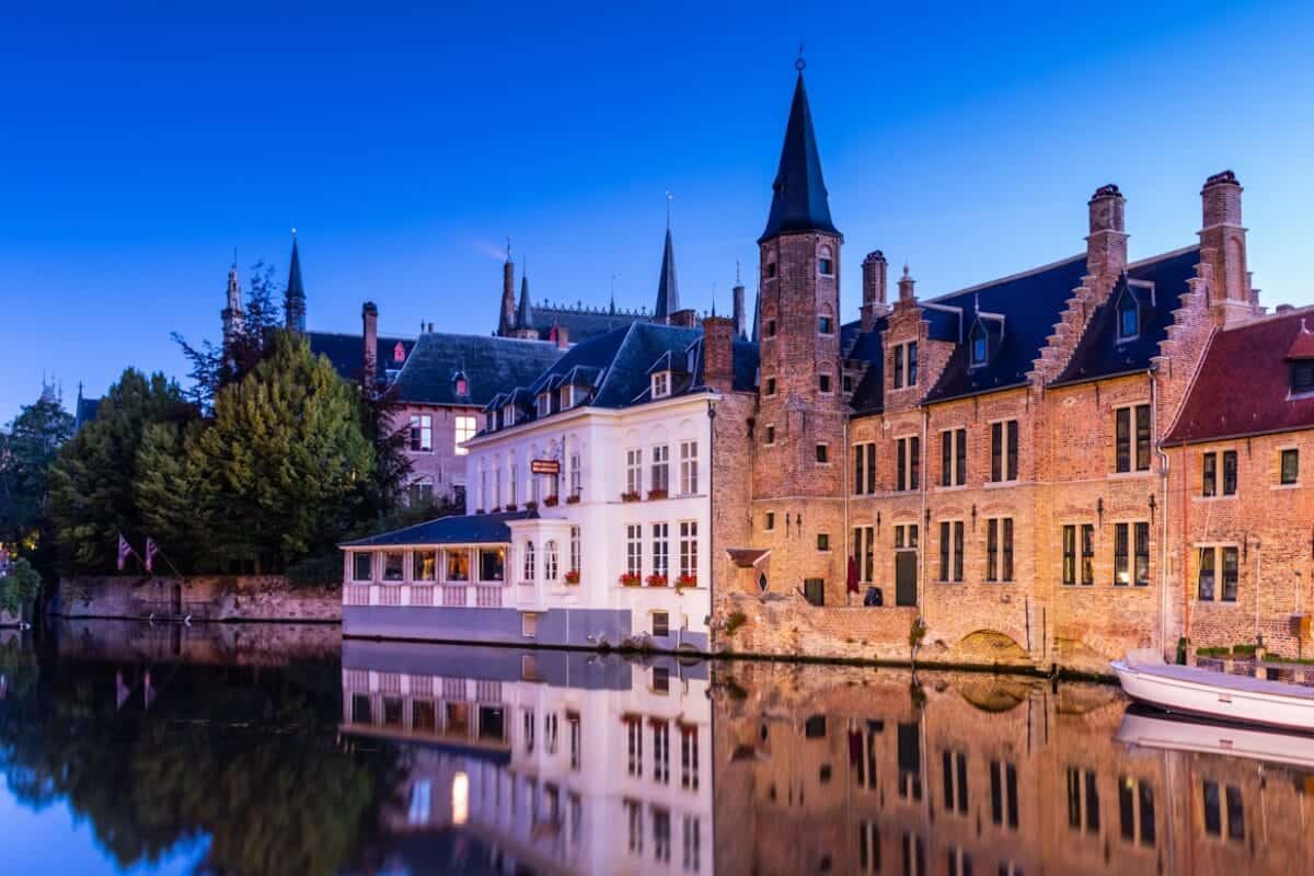 Bruges Travel Guide, brown and white concrete building near body of water during daytime
