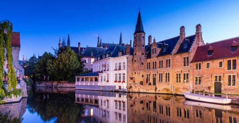 Bruges Travel Guide, brown and white concrete building near body of water during daytime