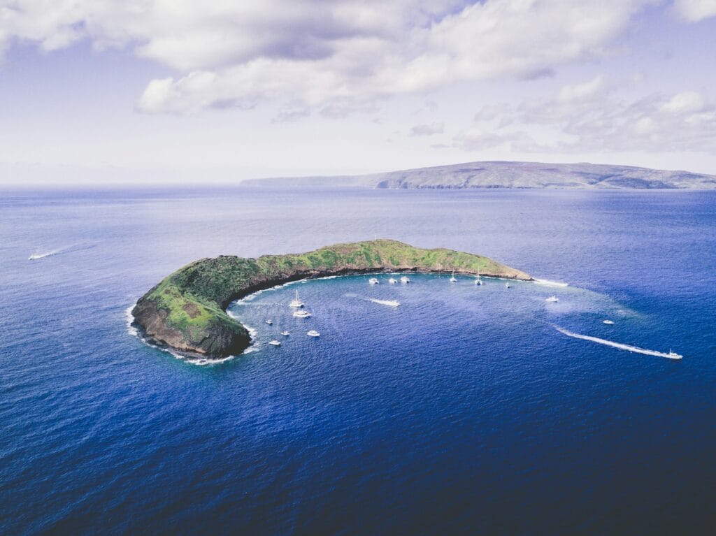 Molokini Crater body of water under white cloudy sky during daytime photo