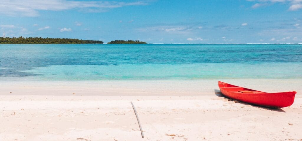 Beach Escapes red kayak on beach shore during daytime