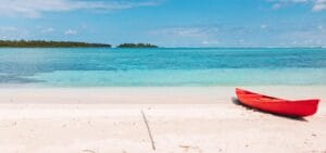 Beach Escapes red kayak on beach shore during daytime