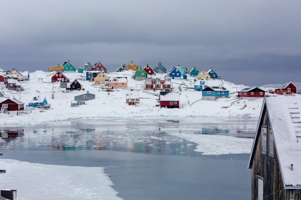 Greenland Tours view photography of assorted-color houses near pond during daytime