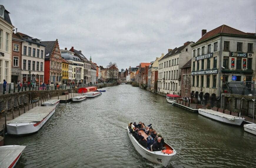 ghent tours people riding on boat on river between buildings during daytime