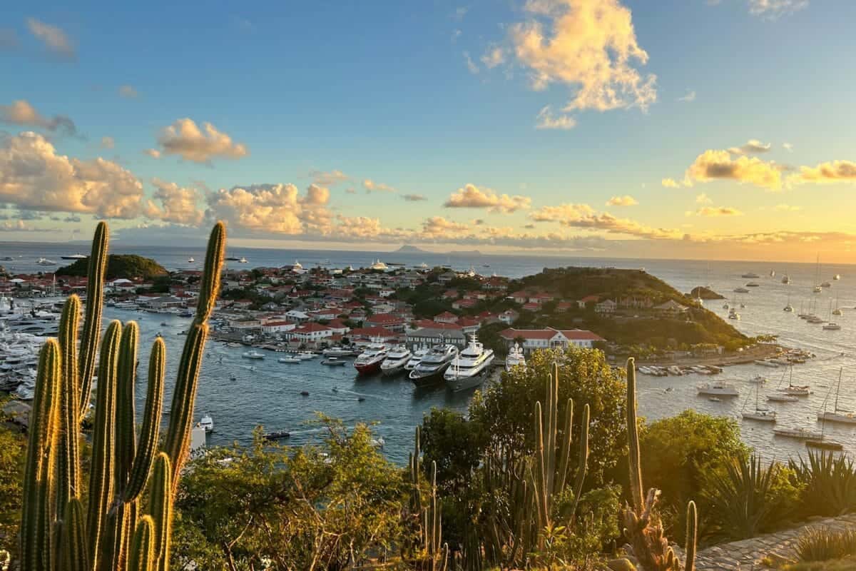 St Barthelemy Travel Guide The sun is setting over a harbor with boats in the water
