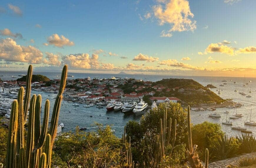 St Barthelemy Travel Guide The sun is setting over a harbor with boats in the water