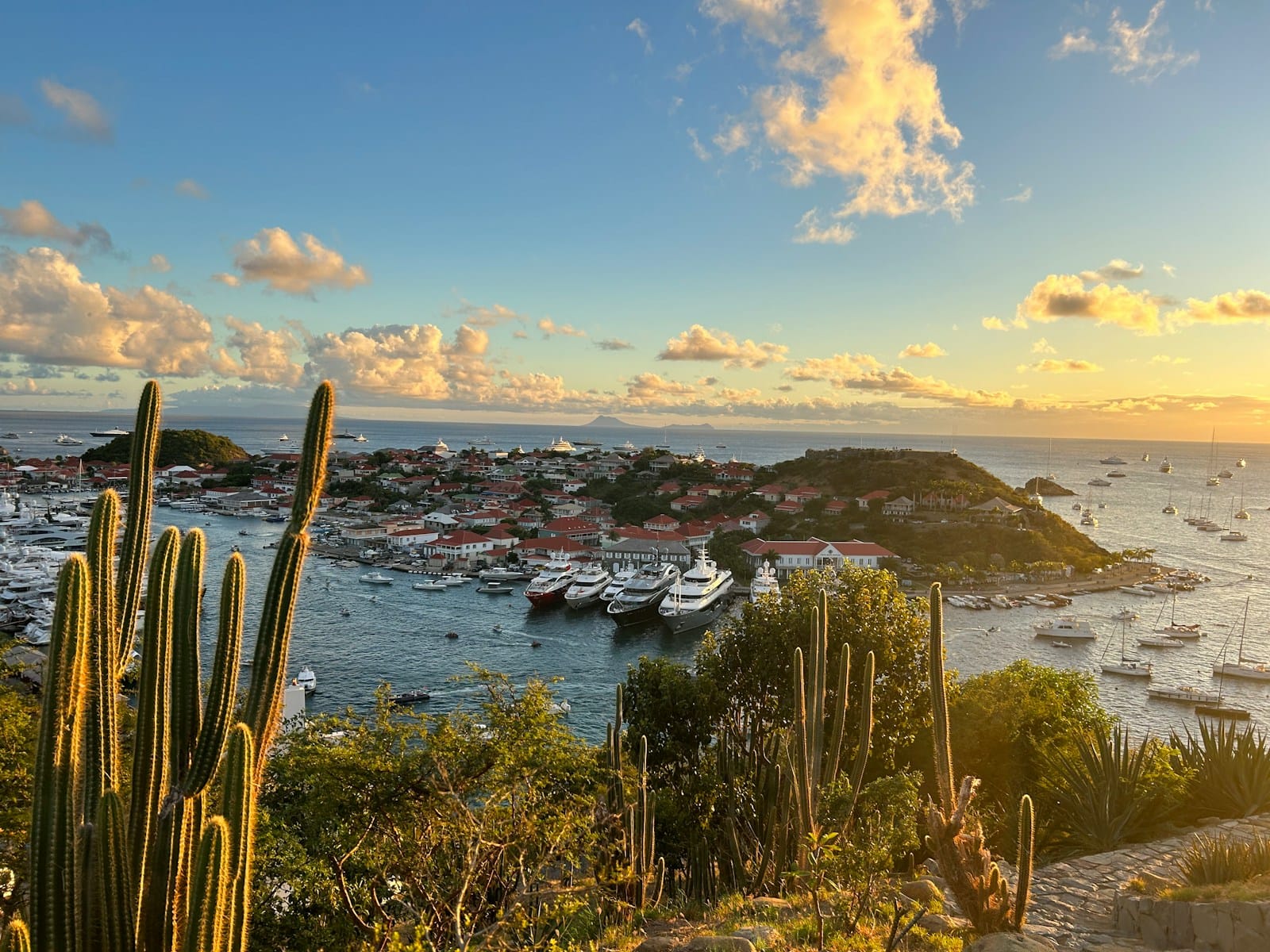 St Barthelemy Travel Guide The sun is setting over a harbor with boats in the water