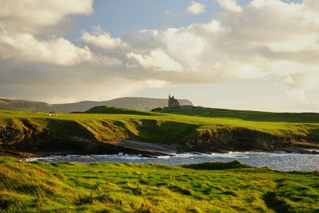 Ireland Tours green grass field under cloudy sky during daytime
