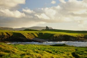 Ireland Tours green grass field under cloudy sky during daytime