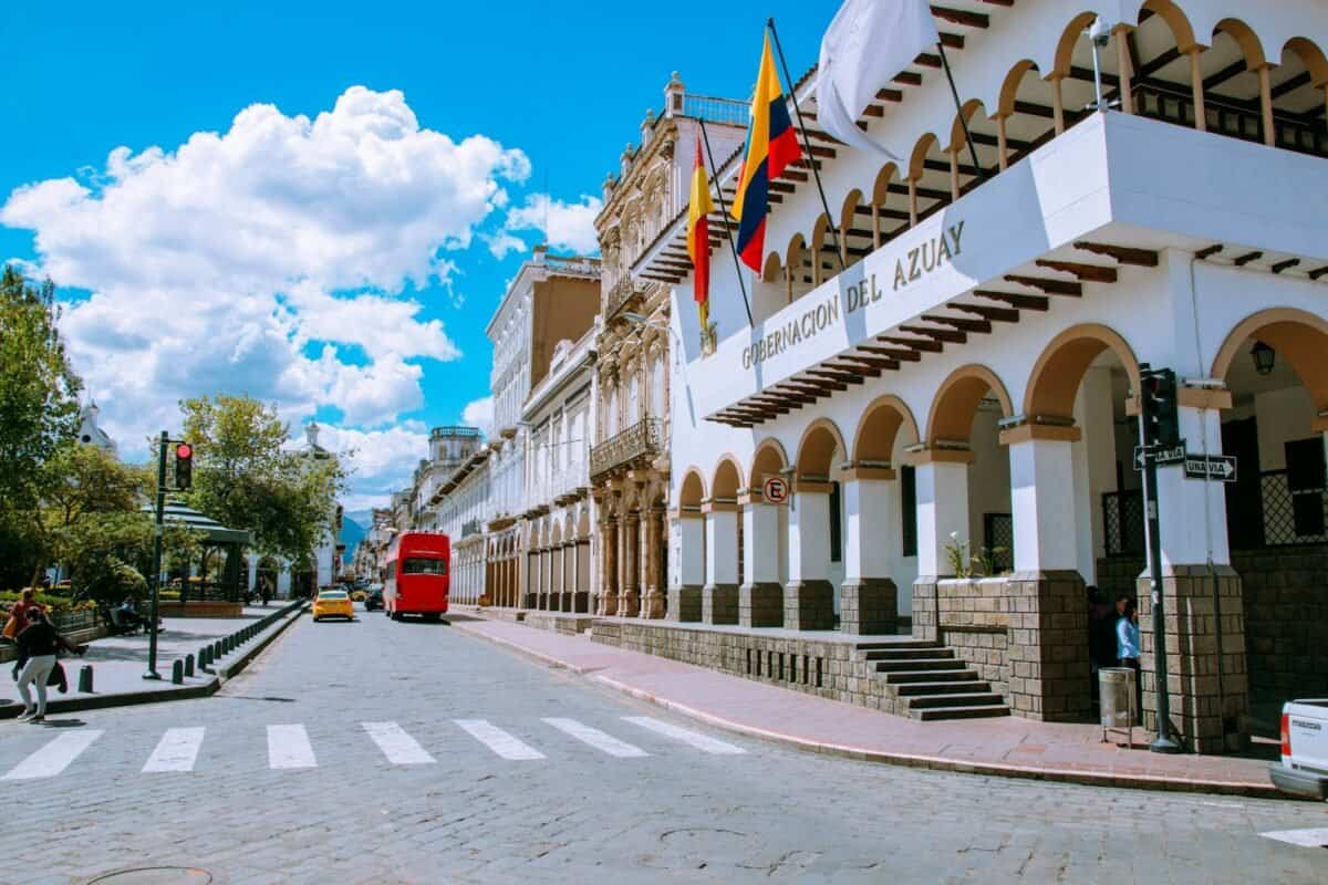 ecuador tours red car parked in front of white concrete building during daytime