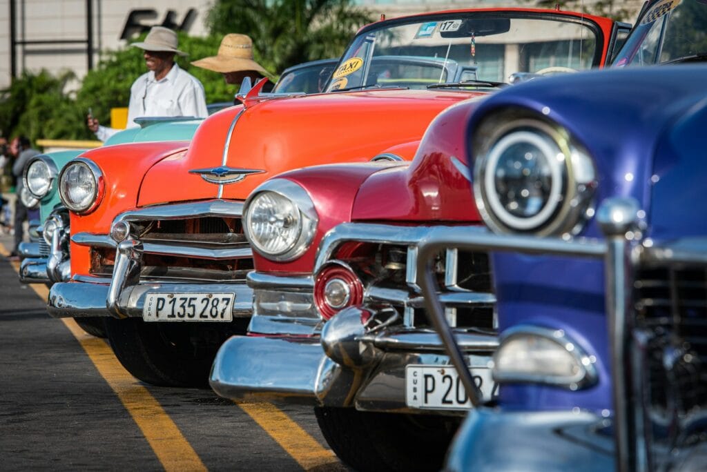 Cuba Travel Guide Uncovering the Culture & Local Traditions orange, red, and blue vintage cars