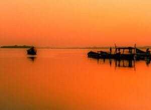 Uganda Travel Guide silhouette of people riding boat on sea during daytime