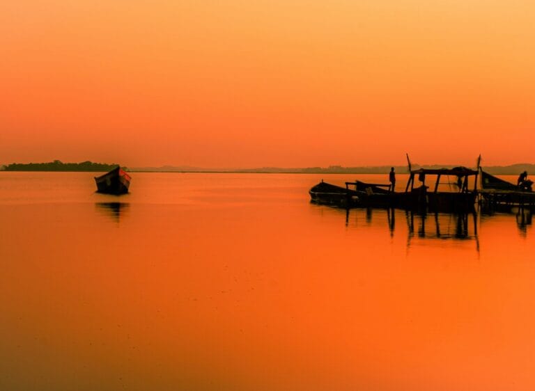 Uganda Travel Guide silhouette of people riding boat on sea during daytime