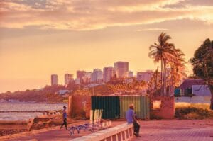 Mozambique Travel Guide man seating beside body of water