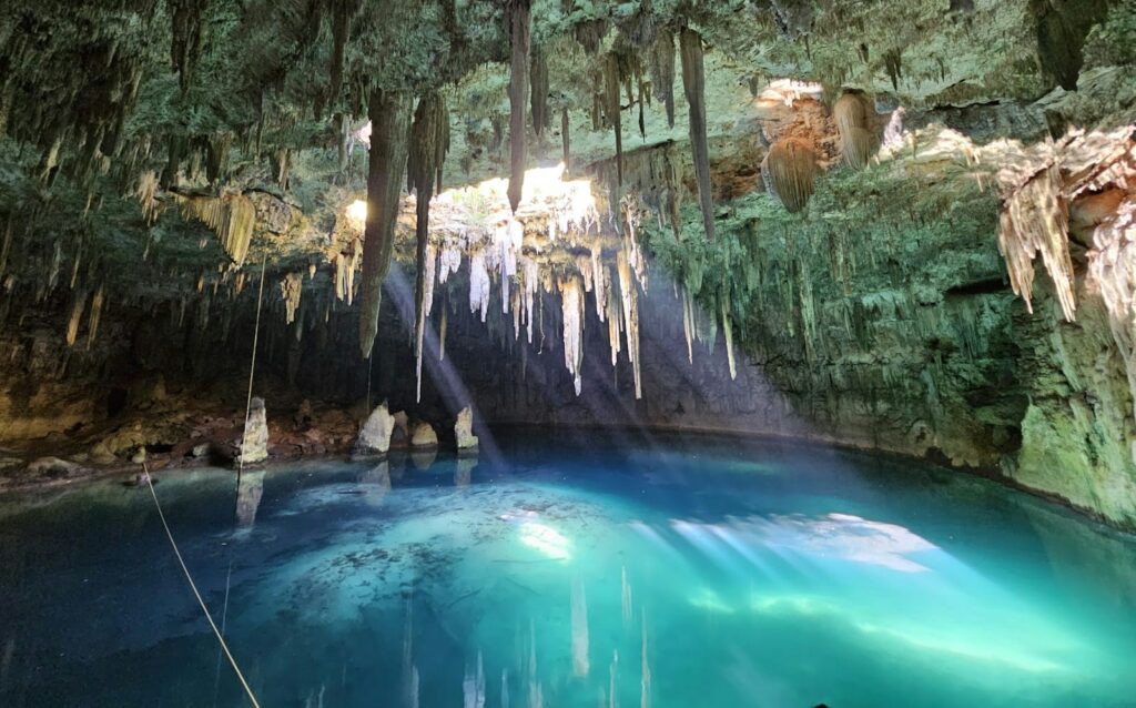 Xplor Park A blue pool in a cave with icicles hanging from the trees