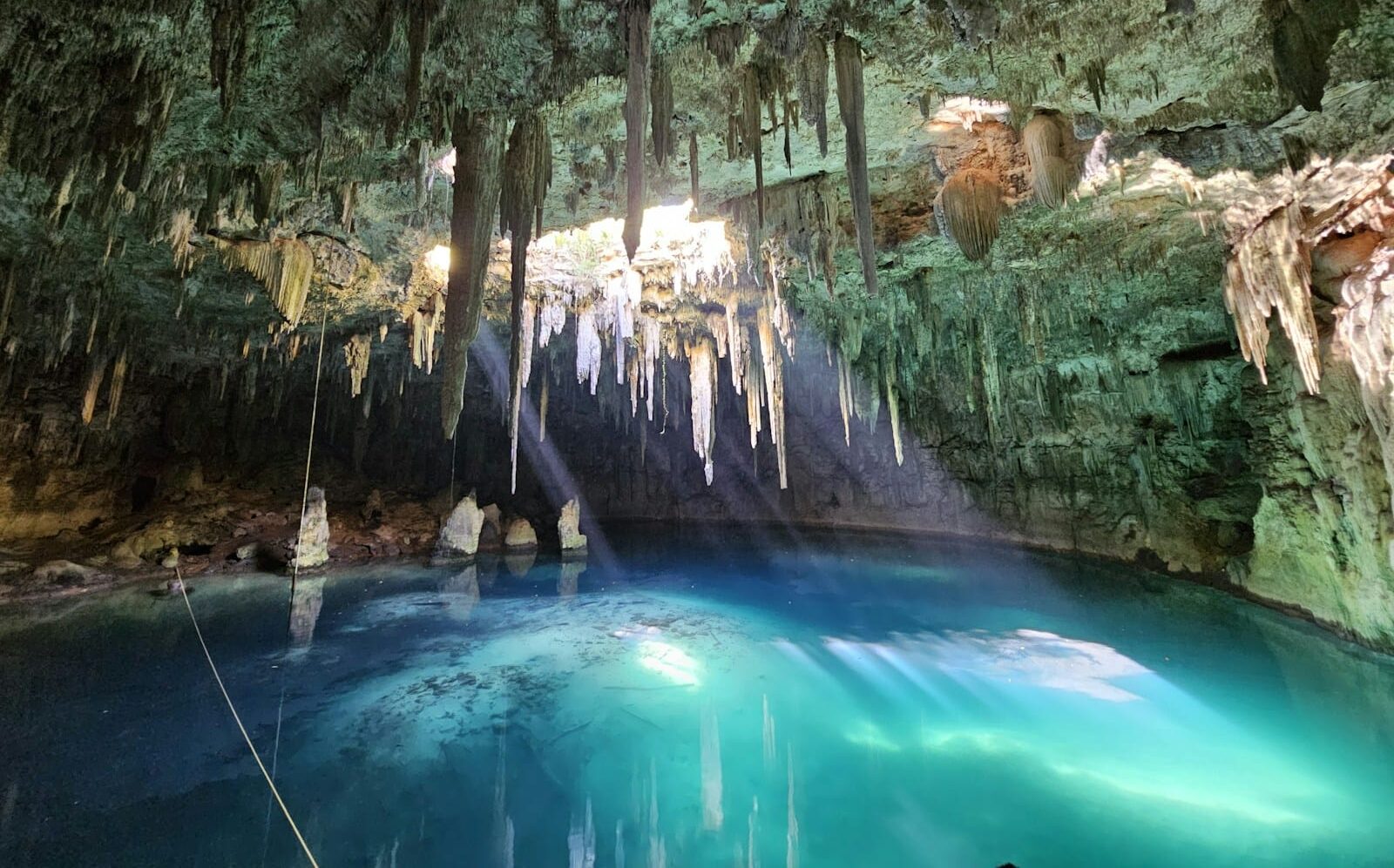 Xplor Park A blue pool in a cave with icicles hanging from the trees