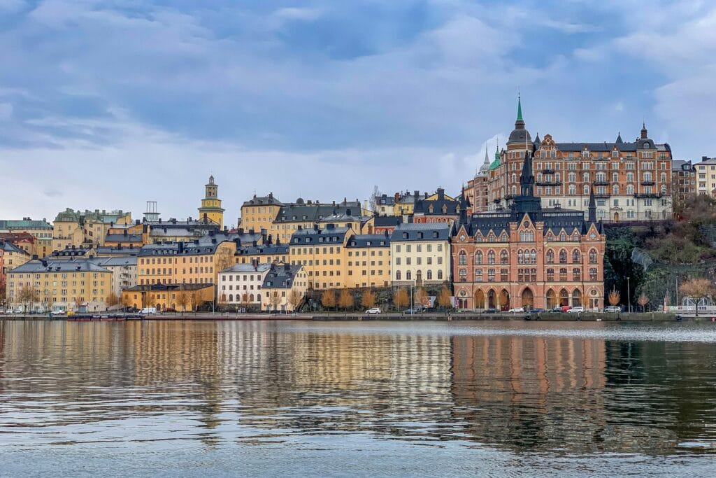 Sweden Tours brown and white concrete building near body of water during daytime