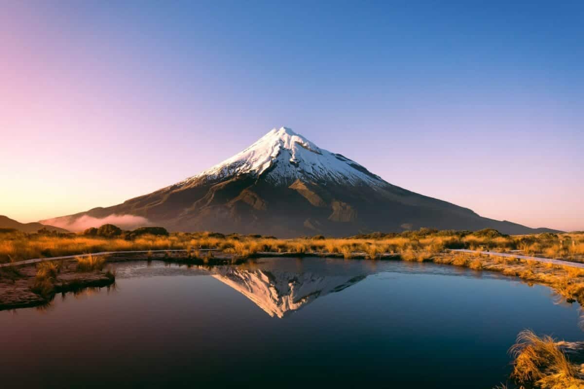 new zealand tours mountain near body of water during daytime