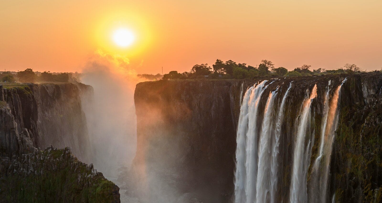 Zimbabwe Travel Guide waterfalls on brown rocky mountain during sunset